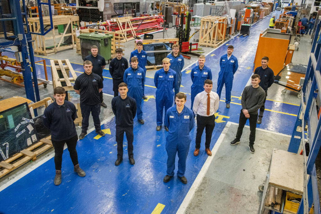 A group of Alexander Dennis employees in a manufacturing factory