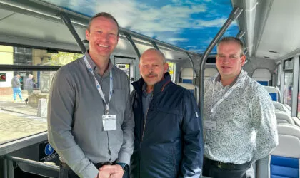 Photo of three white men standing inside a bus
