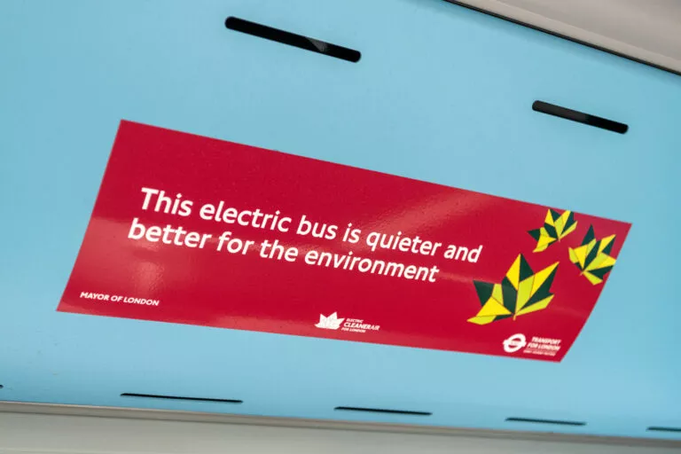 Close-up of a poster which says 'This electric bus is quieter and better for the environment.'